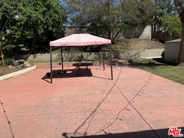 a table and chairs in the patio with a barbeque
