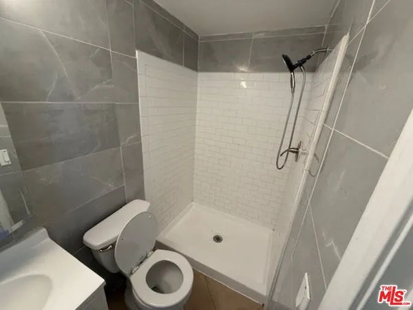 a bathroom with a shower a toilet and a sink