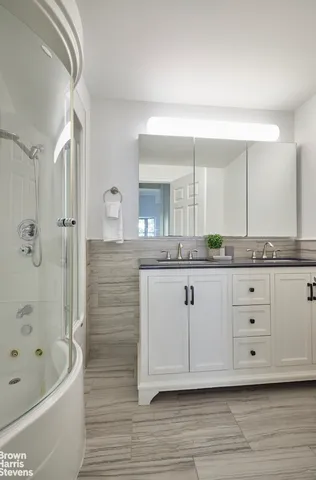 a spacious bathroom with a granite countertop sink a mirror and bathtub