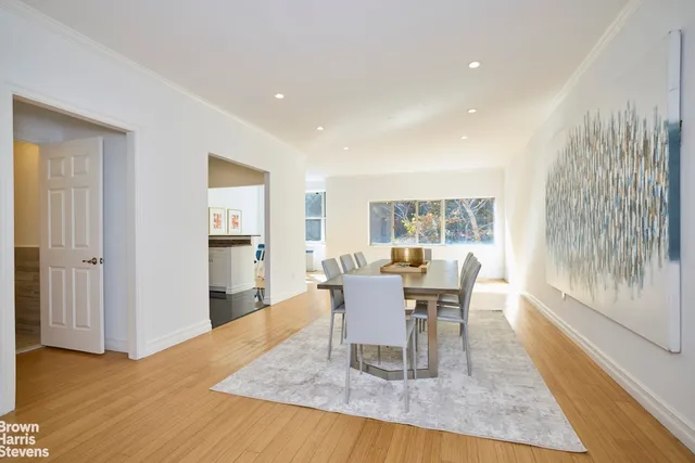 a dining room with wooden floor and a floor to ceiling window