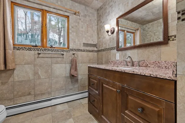 a bathroom with a granite countertop sink a mirror and a shower