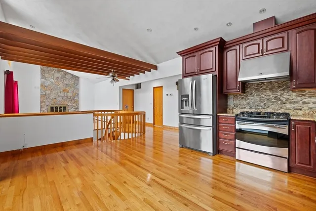 a kitchen with stainless steel appliances granite countertop a refrigerator microwave and stove with wooden floor