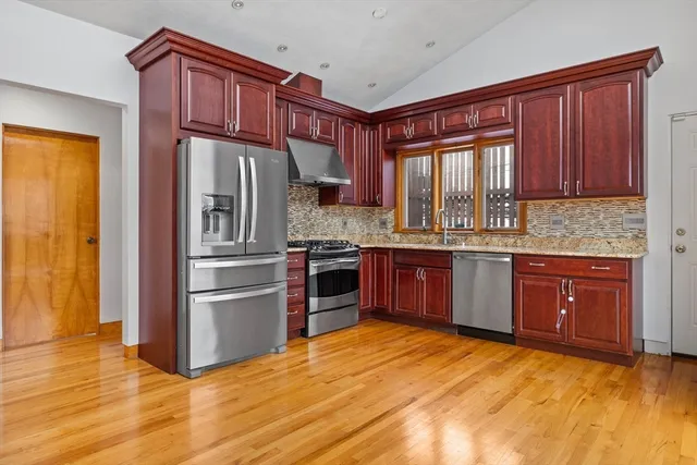 a kitchen with stainless steel appliances granite countertop a refrigerator and a sink