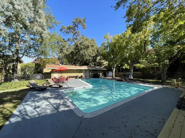 a backyard of a house with barbeque oven table and chairs