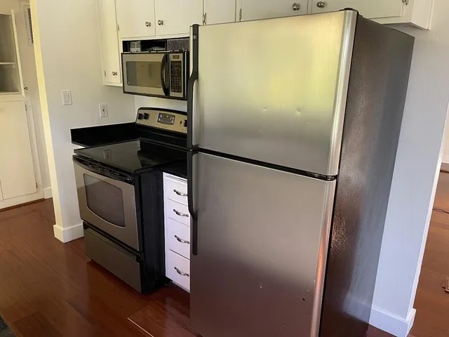 a white refrigerator freezer and a stove sitting inside of a kitchen