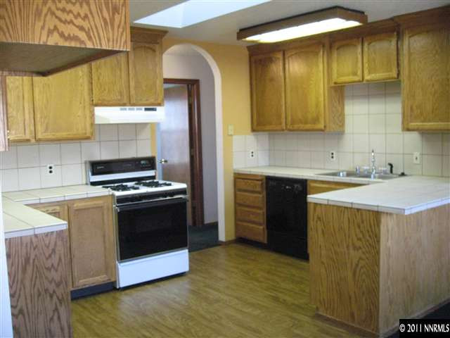 2849 Wade Street Minden, NV 89423 - Photo 2 of 13 a kitchen with kitchen island granite countertop a sink and a stove top oven