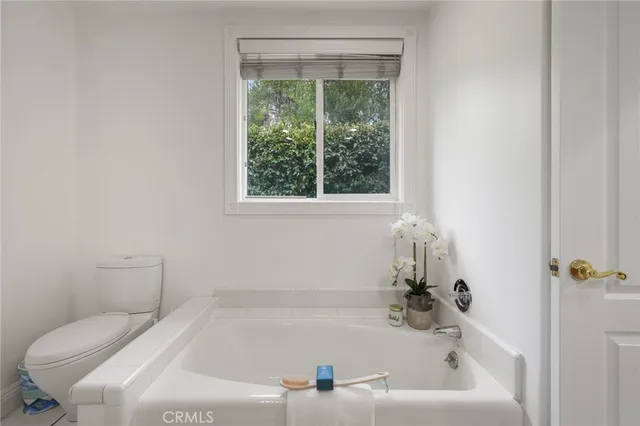 a bedroom with a bed and large windows