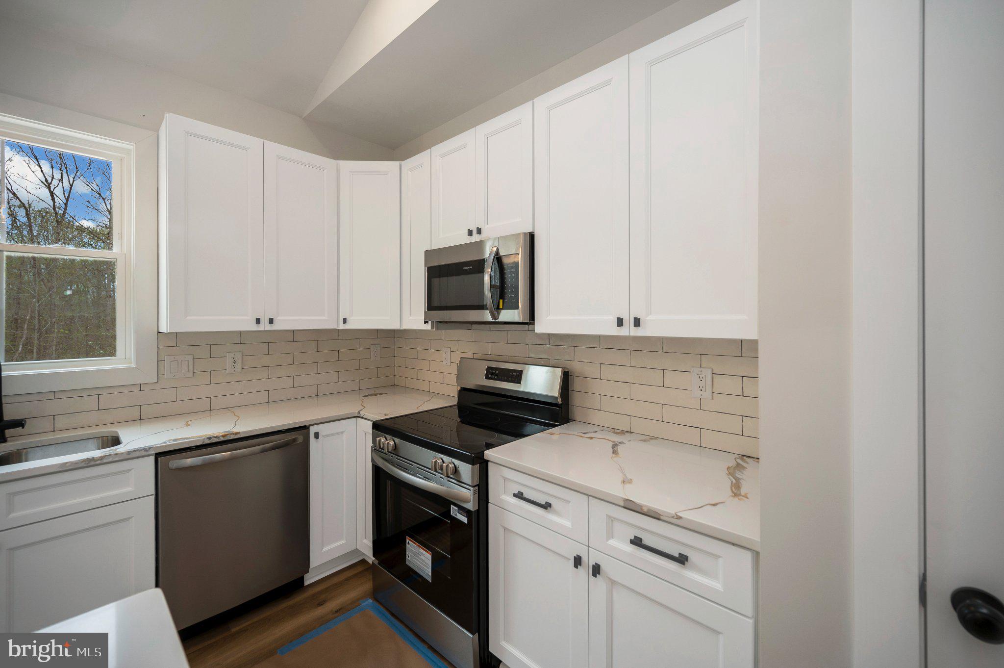 17342 Mallorys Ford Road Gordonsville, VA 22942 - Photo 23 of 38 a kitchen with granite countertop white cabinets and stainless steel appliances