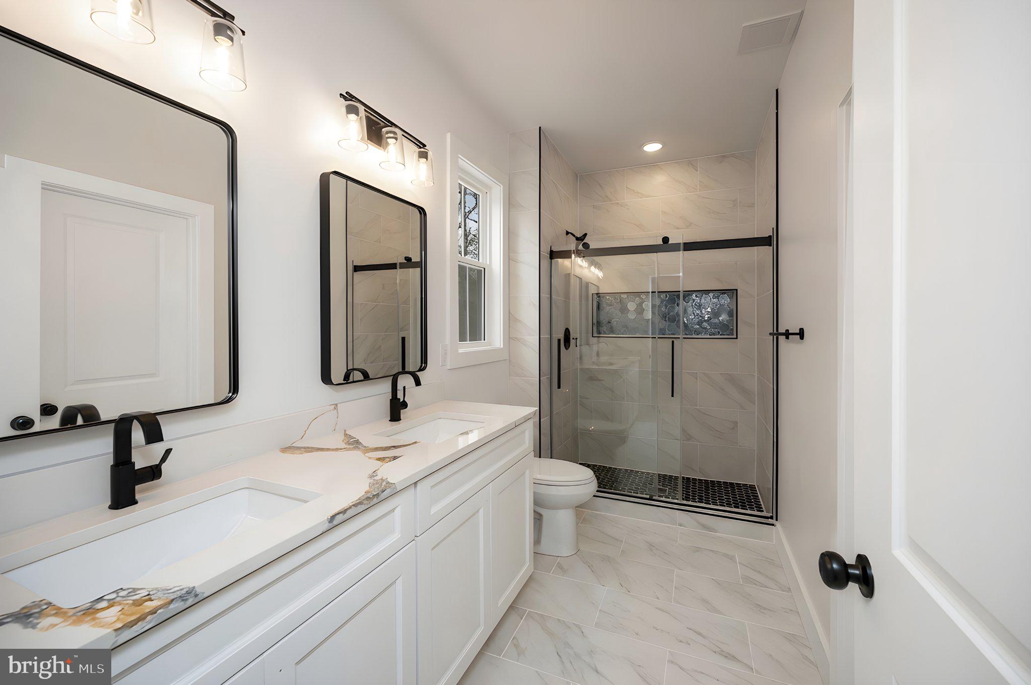 17342 Mallorys Ford Road Gordonsville, VA 22942 - Photo 30 of 38 a bathroom with a double vanity sink toilet mirror and shower