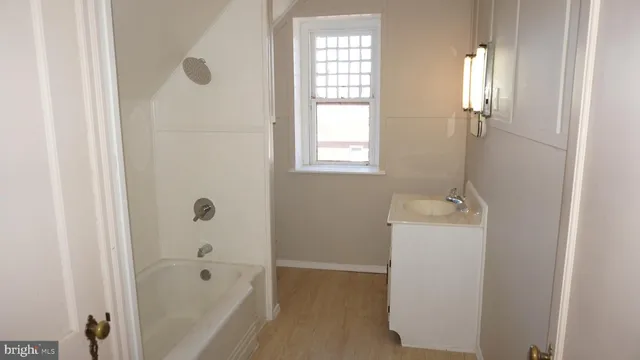 a bathroom with a sink a window and shower