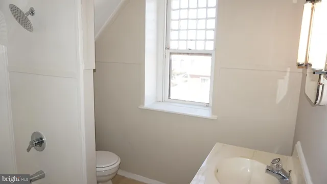 a white toilet sitting next to a window