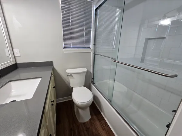 a white toilet sitting next to a bathroom sink and a window