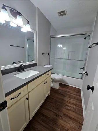 a bathroom with a double vanity sink a toilet and a mirror