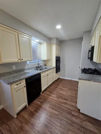 a kitchen with stainless steel appliances granite countertop a sink stove and cabinets