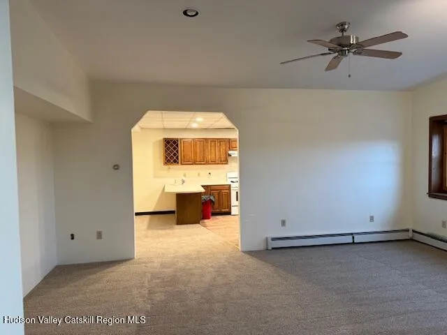 an empty room with a ceiling fan and window