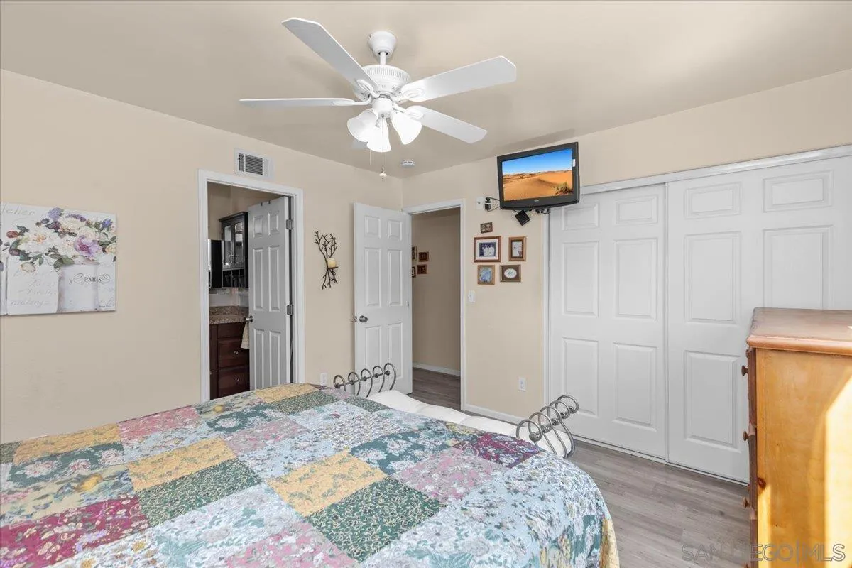 9254 Shadow Hill Road Santee, CA 92071 - Photo 25 of 34 a bedroom with a large bed a chandelier and closet