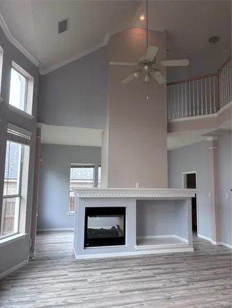 a view of an empty room with a window and fireplace