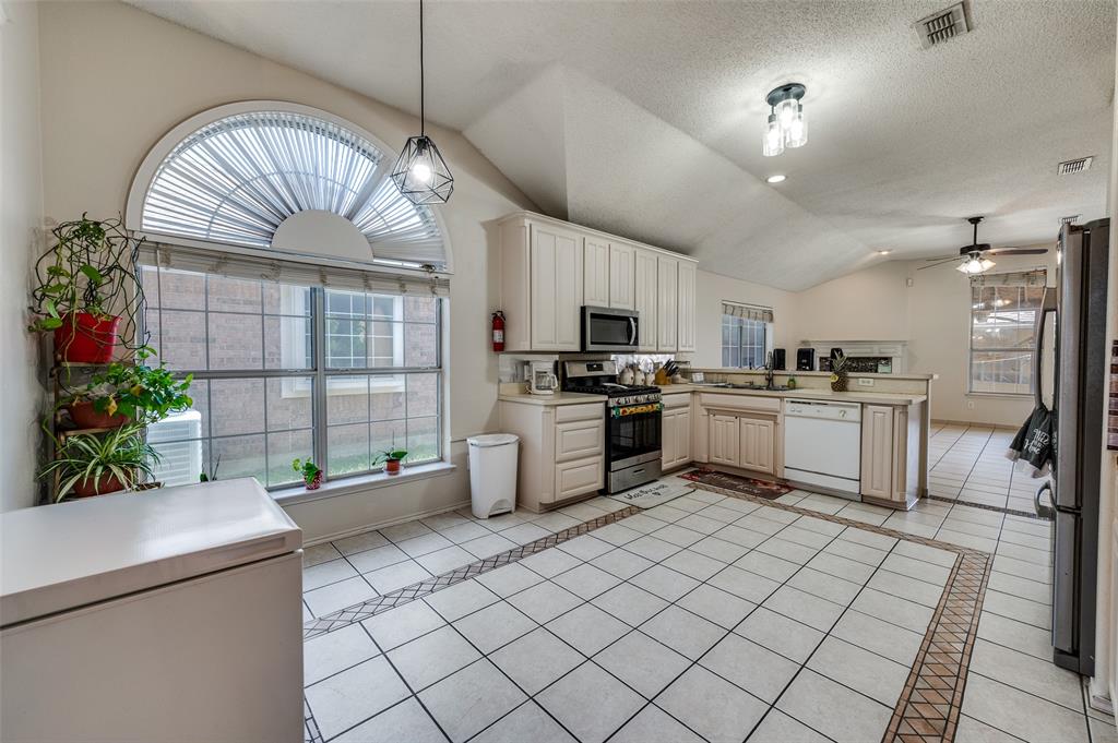 9120 River Trails Boulevard Fort Worth, TX 76118 - Photo 11 of 25 a kitchen with stainless steel appliances kitchen island granite countertop a sink a counter space cabinets and a living room view