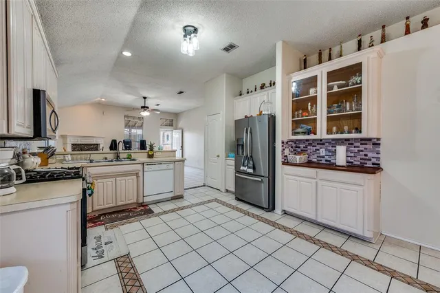 a kitchen with stainless steel appliances kitchen island granite countertop a refrigerator and a stove top oven