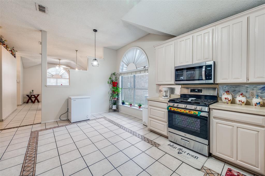 9120 River Trails Boulevard Fort Worth, TX 76118 - Photo 13 of 25 a kitchen with stainless steel appliances granite countertop a stove a sink and a white cabinets
