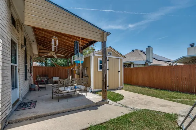 a patio with a table and chairs and potted plants