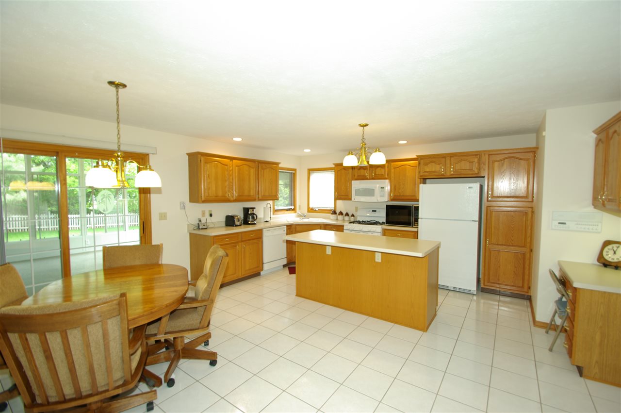 7254 Sentinel Road Rockford, IL 61107 - Photo 5 of 25 a kitchen with a dining table chairs and white appliances
