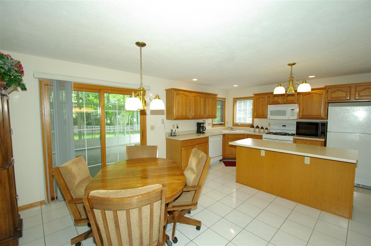7254 Sentinel Road Rockford, IL 61107 - Photo 8 of 25 a kitchen with stainless steel appliances kitchen island granite countertop a refrigerator a stove top oven and a dining table with the view