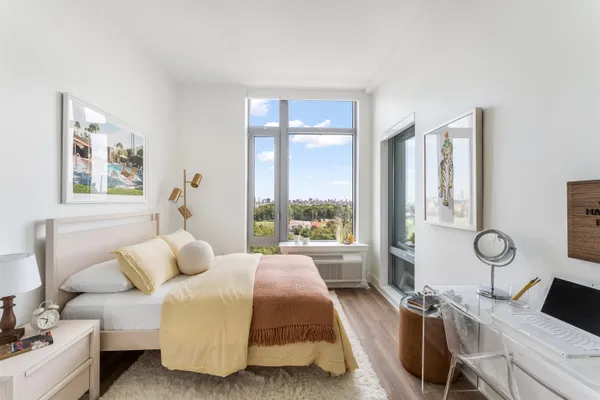 a spacious bedroom with a bed and a large window