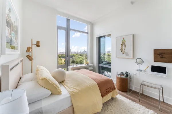 a bedroom with a bed and a large window