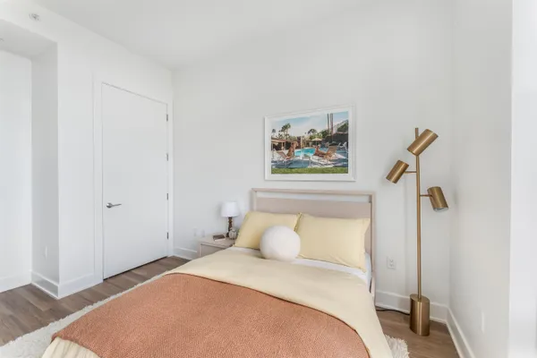 a bedroom with a bed and painting on the wall