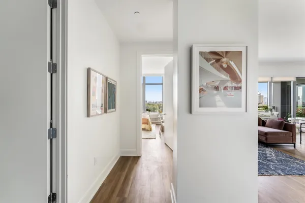 a view of a hallway with wooden floor and furniture