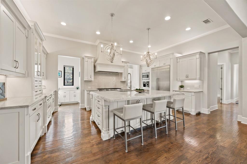 809 Legacy Trail Colleyville, TX 76034 - Photo 12 of 40 an open kitchen with white cabinets and stainless steel appliances