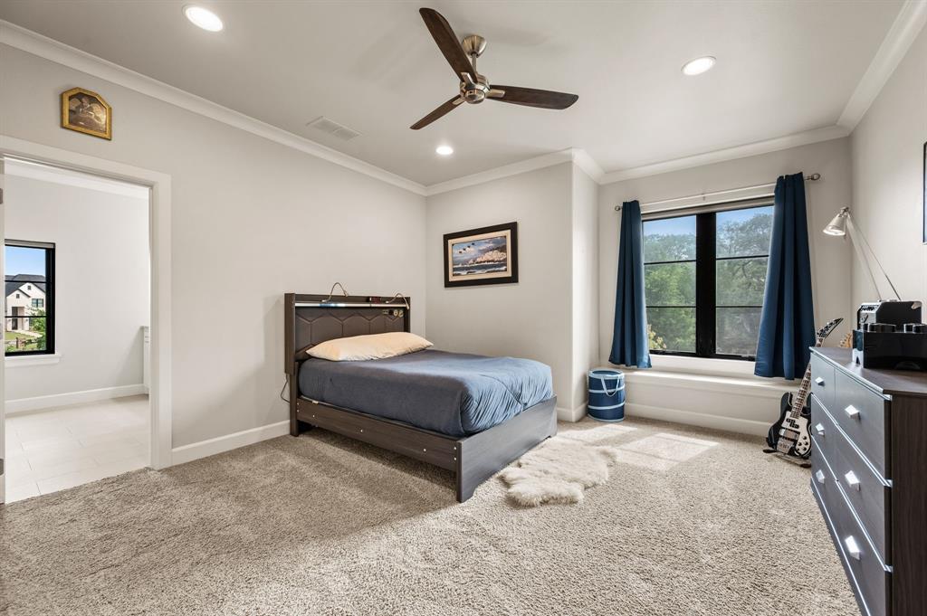809 Legacy Trail Colleyville, TX 76034 - Photo 25 of 40 a bedroom with a large bed and a chandelier