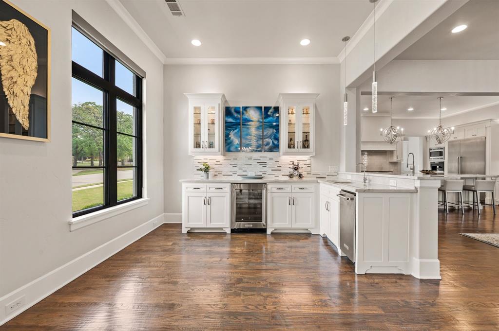 809 Legacy Trail Colleyville, TX 76034 - Photo 10 of 40 a large white kitchen with granite countertop a stove top oven a sink and white cabinets with wooden floor
