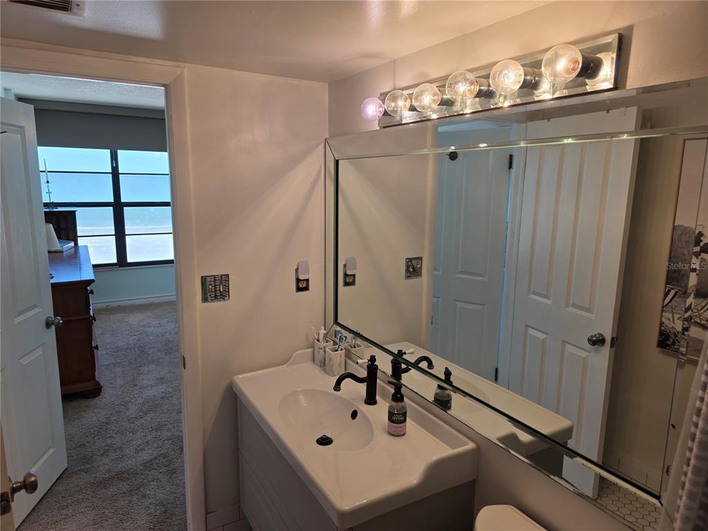 17580 Gulf Boulevard, Unit 311 Redington Shores, FL 33708 - Photo 22 of 34 a bathroom with a sink mirror and shower