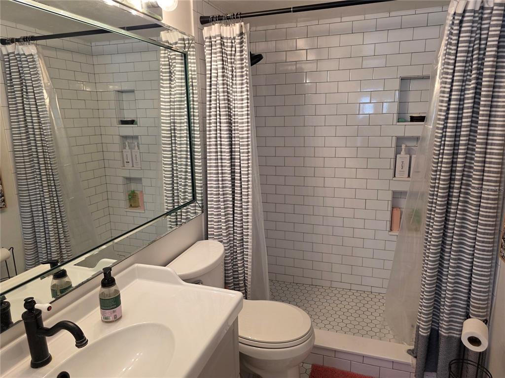 17580 Gulf Boulevard, Unit 311 Redington Shores, FL 33708 - Photo 23 of 34 a bathroom with a sink a toilet and shower