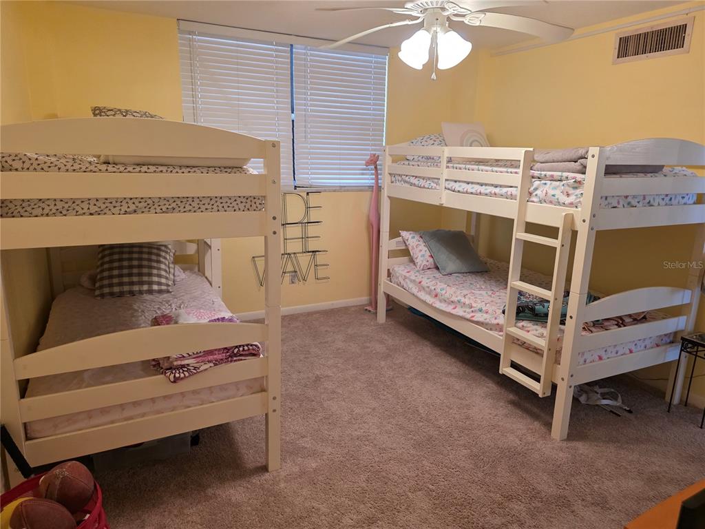 17580 Gulf Boulevard, Unit 311 Redington Shores, FL 33708 - Photo 24 of 34 a bedroom with a bunk bed and a dresser
