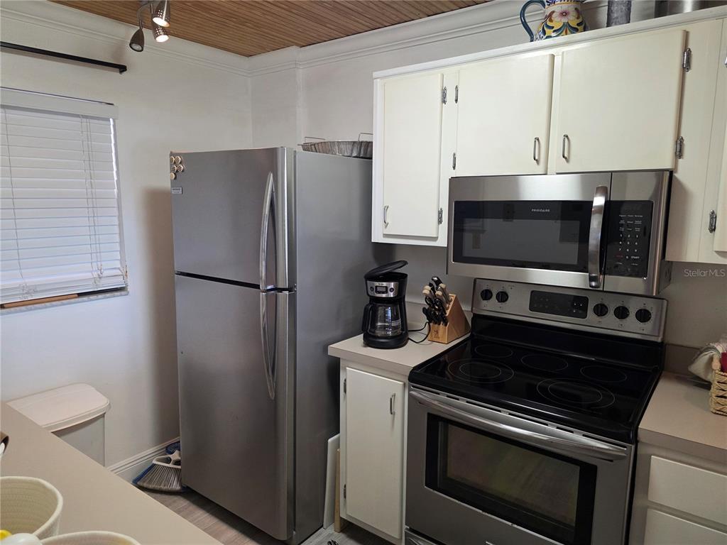 17580 Gulf Boulevard, Unit 311 Redington Shores, FL 33708 - Photo 26 of 34 a kitchen with stainless steel appliances a refrigerator stove and microwave