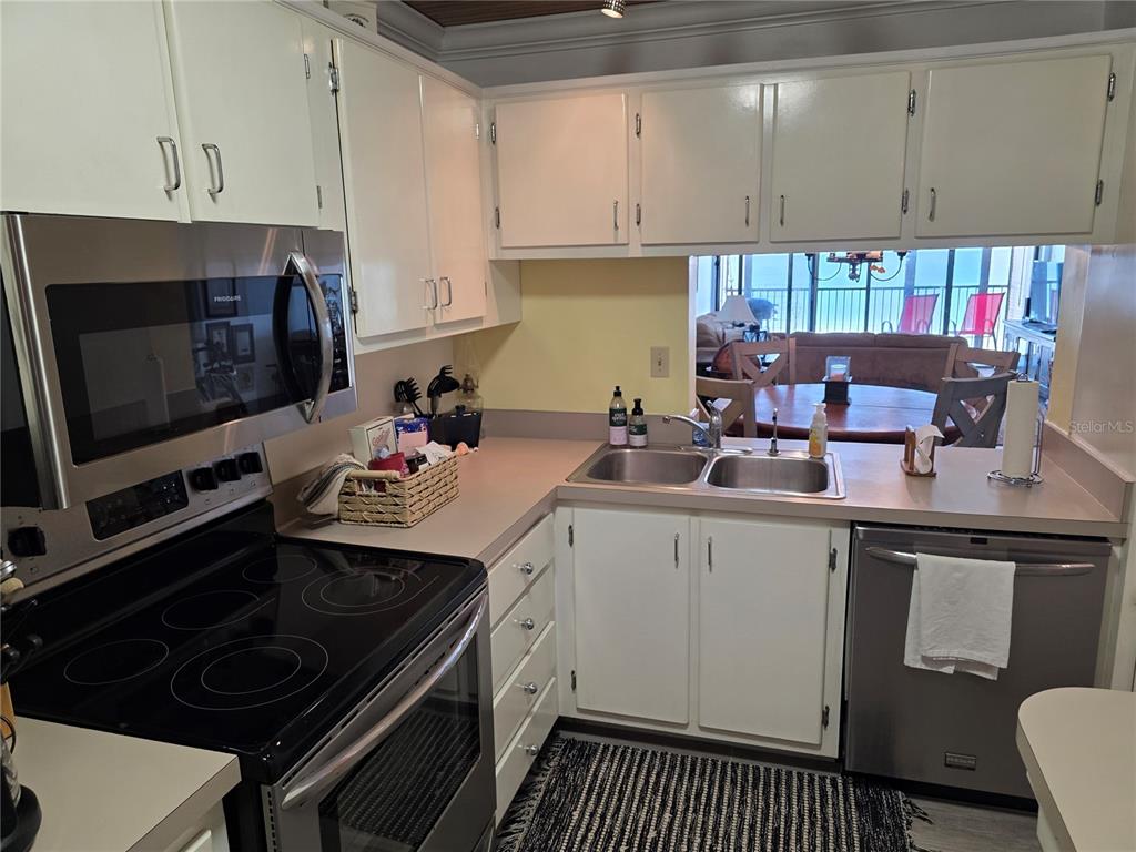 17580 Gulf Boulevard, Unit 311 Redington Shores, FL 33708 - Photo 28 of 34 a kitchen with a sink stove and cabinets