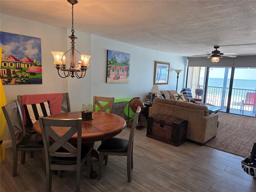 17580 Gulf Boulevard, Unit 311 Redington Shores, FL 33708 - Photo 7 of 34 a view of a dining room with furniture a chandelier and wooden floor