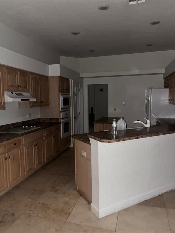 8125 Courtleigh Drive Orlando, FL 32835 - Photo 18 of 26 a kitchen with stainless steel appliances a sink stove and refrigerator