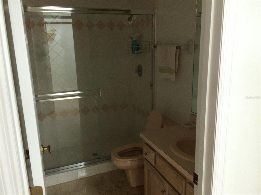 8125 Courtleigh Drive Orlando, FL 32835 - Photo 20 of 26 a bathroom with a granite countertop toilet and a shower