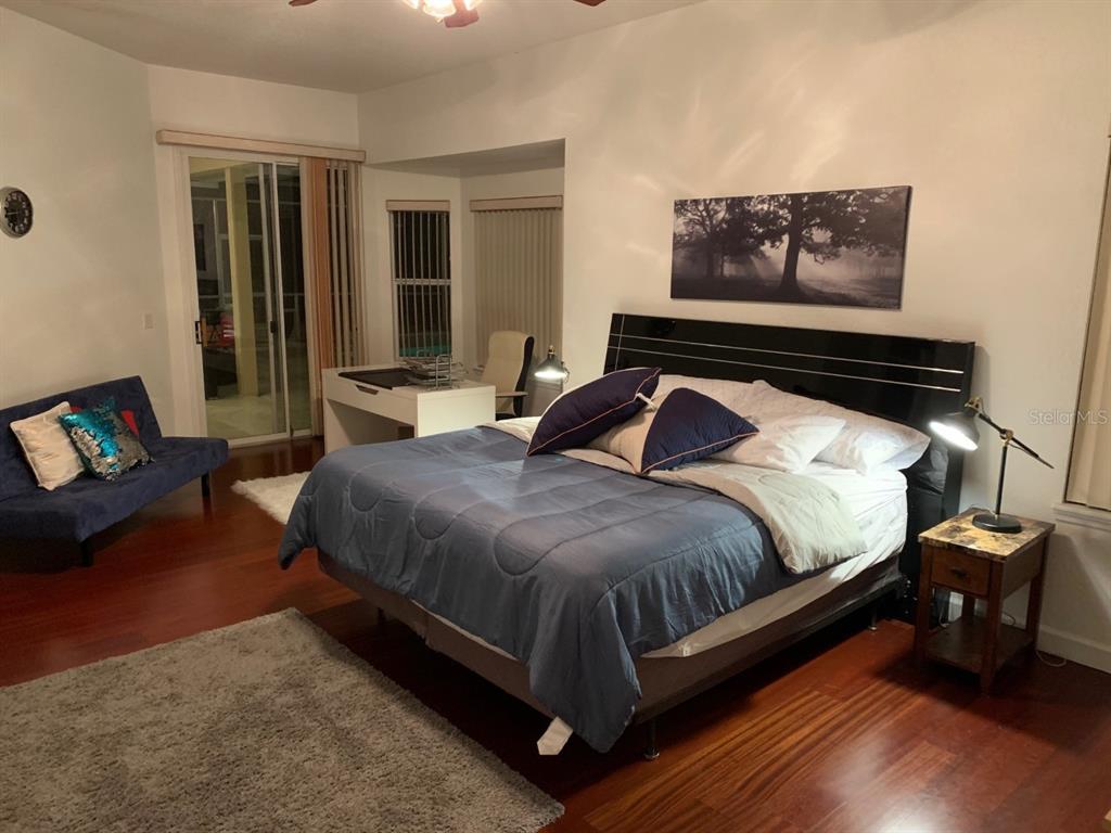 8125 Courtleigh Drive Orlando, FL 32835 - Photo 21 of 26 a bedroom with a bed and wooden floor