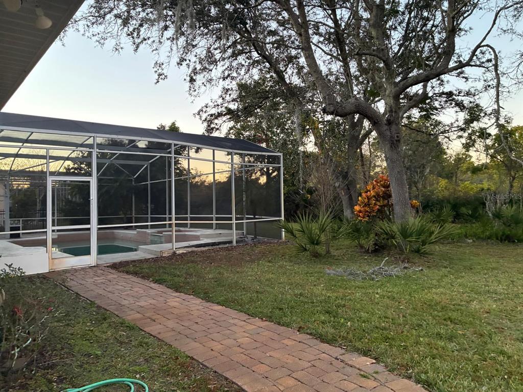 8125 Courtleigh Drive Orlando, FL 32835 - Photo 25 of 26 a view of a backyard with floor to ceiling window and a yard