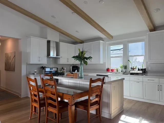 a kitchen with granite countertop a table chairs microwave and cabinets
