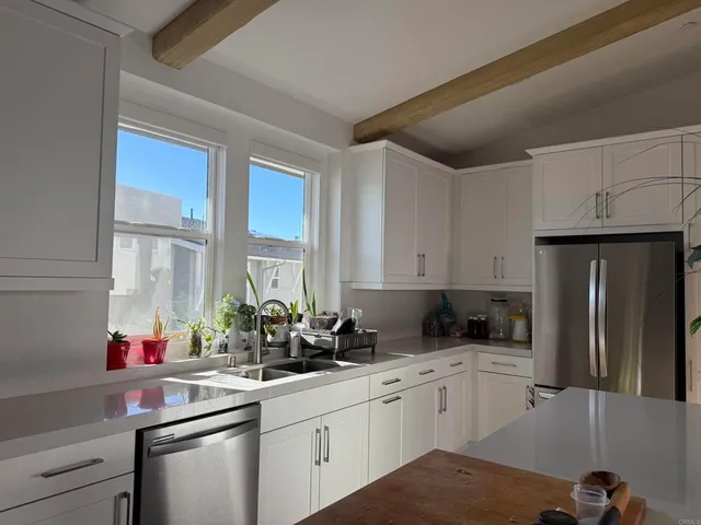 a kitchen with stainless steel appliances a sink a window and cabinets