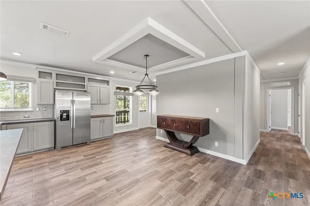 a view of a kitchen with wooden floor and a refrigerator