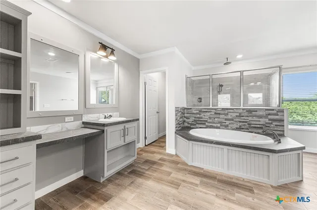 a bathroom with a double vanity sink mirror and bathtub
