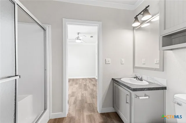 a bathroom with a granite countertop sink a mirror and a shower