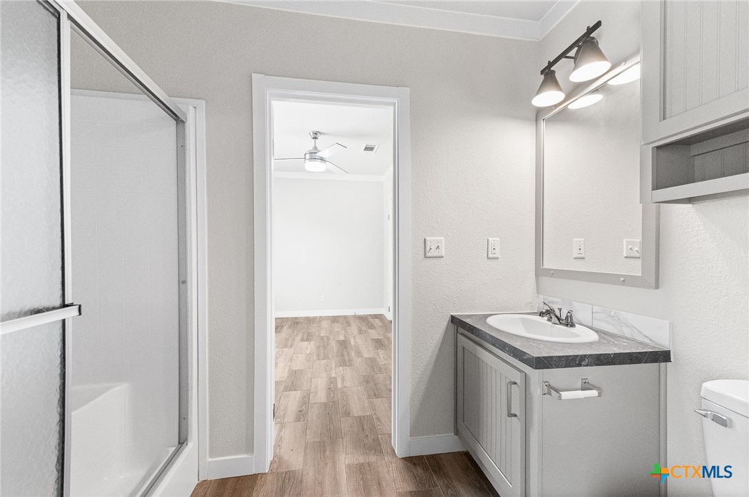 9130 Rebecca Creek Road Spring Branch, TX 78070 - Photo 28 of 41 a bathroom with a granite countertop sink a mirror and a shower